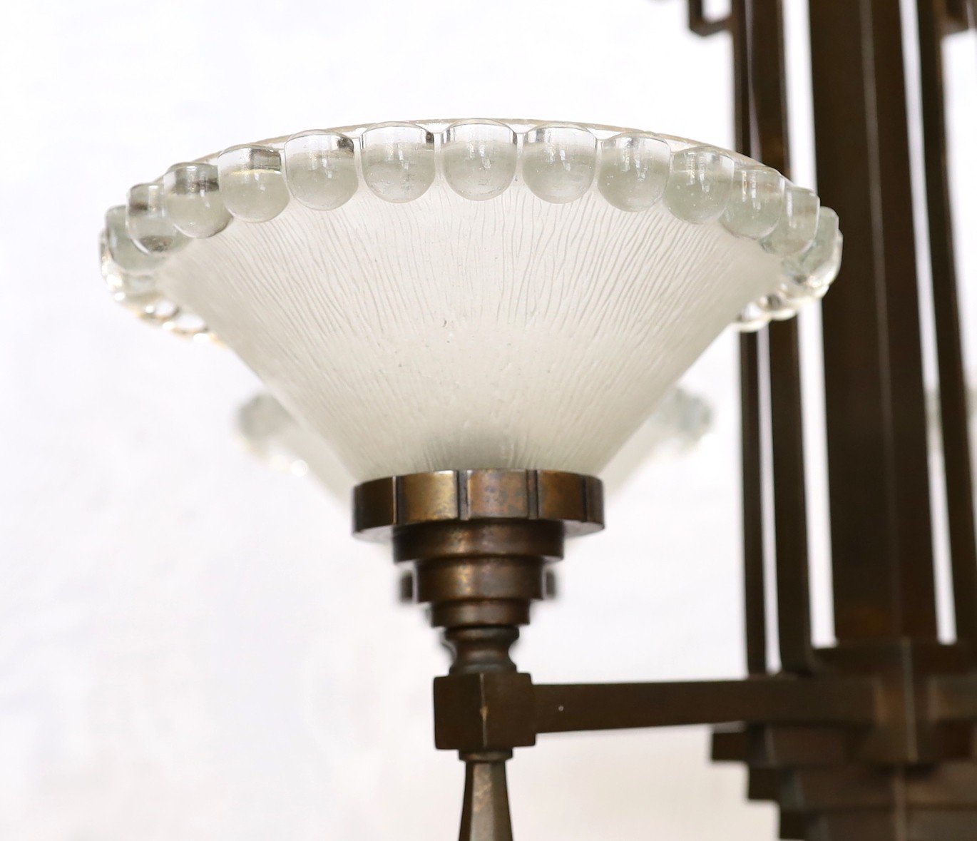 An Art Deco bronze and glass light fitting with four beaded frosted shades. height 81cm. width 54cm